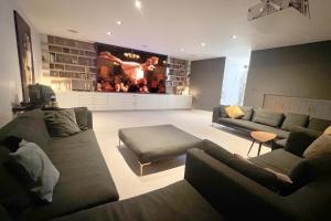 a living room with two couches and a large screen at One Park Lane in Southwell