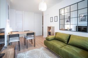 ein Wohnzimmer mit einem grünen Sofa und einem Tisch in der Unterkunft Welcome to your cocoon near Paris in Arcueil