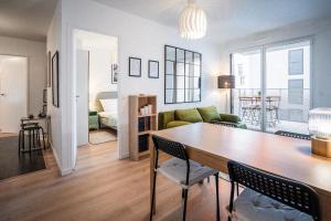 ein Wohnzimmer mit einem Tisch und einem Sofa in der Unterkunft Welcome to your cocoon near Paris in Arcueil