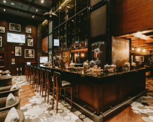 a bar with a row of chairs in a restaurant at Hilton Doha The Pearl in Doha