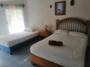 1 dormitorio con 2 camas, lámpara y espejo en Casa Las Animas en El Carmen