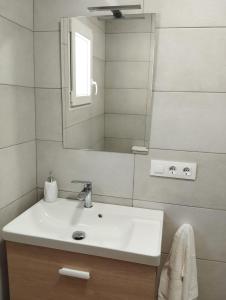 uma casa de banho com um lavatório branco e um espelho. em CAN’SELMA 2 em Chella