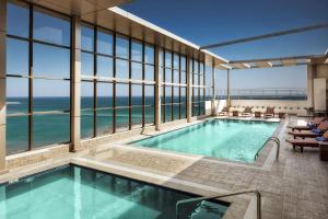 a swimming pool with a view of the ocean at Hilton Garden Inn Al Jubail in Al Jubail