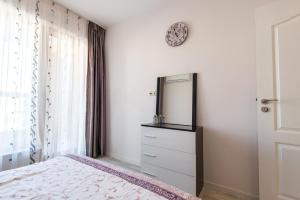 una camera da letto con cassettiera e specchio sul muro di La Mer Luxury Apartments a Golden Sands