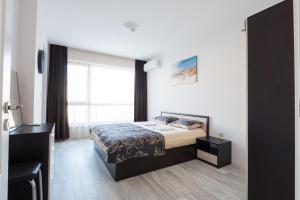 una camera con un letto e una grande finestra di La Mer Luxury Apartments a Golden Sands