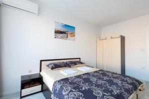 1 dormitorio con 1 cama con colcha azul y blanca en La Mer Luxury Apartments, en Golden Sands