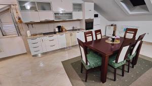 a kitchen with a table and chairs in a kitchen at Apartmani Antonia Nakić -Stobreč in Split