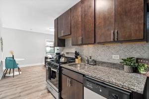 a kitchen with a sink and a stove and cabinets at 1-bedroom Chic Apartment with Laundry - Brompton 55-57 rep in Chicago