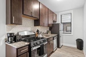 a kitchen with a stove and a refrigerator at 1-bedroom Chic Apartment with Laundry - Brompton 55-57 rep in Chicago