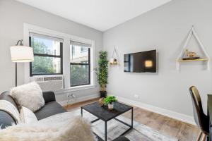 a living room with a couch and a tv at 1-bedroom Chic Apartment with Laundry - Brompton 55-57 rep in Chicago