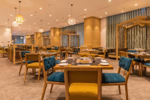 uma sala de jantar com mesas, cadeiras e lustres em Hilton Garden Inn Casablanca Sud em Casablanca