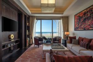 a living room with a couch and a table and a tv at Hilton Tangier Al Houara Resort & Spa in Al Houara