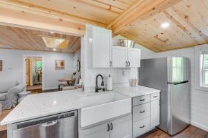 een keuken met witte apparatuur en een houten plafond bij Welcoming Williams Bay Cottage with Deck and Fire Pit! in Lake Geneva