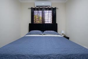 a bedroom with a blue bed with a window at Luxury, cozy apartment Malecon / 3 min Downtown in Santo Domingo