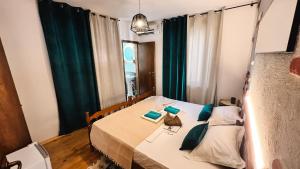 Un dormitorio con una cama con almohadas verdes. en Guest house Mirah en Ulcinj