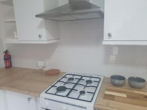 cocina blanca con fogones en Quiet house 8 mins from NEC/AIRPORT en Marston Green