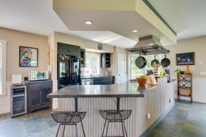 a kitchen with a large island with two stools at Hardwick Family Home on VAST Snowmobile Trail in Hardwick