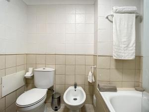 a white bathroom with a toilet and a bath tub at Sea & Mountain by Atlantic Holiday in Funchal +19 photos
