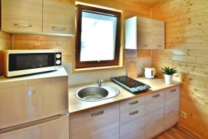 a small kitchen with a sink and a microwave at Comfortable holiday homes Mielno in Mielno