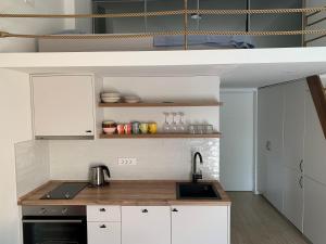 a kitchen with white cabinets and a sink at Sunny studio apartment Chiara in Tivat