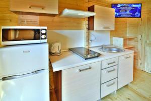 a kitchen with a white refrigerator and a microwave at Comfortable holiday homes Mielno in Mielno