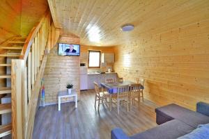 una habitación con mesa y una cocina en una cabaña en Comfortable holiday homes Mielno, en Mielno