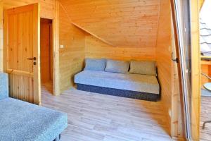 a small room with a bed in a wooden cabin at Comfortable holiday homes Mielno in Mielno