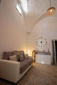 a living room with a couch and a clock on the wall at Casa Vacanze in Salento A casa di Benedetta in Squinzano