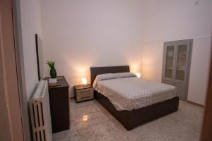 una camera con un letto e due comodini con candele di Casa Vacanze in Salento A casa di Benedetta a Squinzano