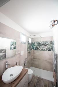 La salle de bains est pourvue d'un lavabo, de toilettes et d'une douche. dans l'établissement Casa Vacanze in Salento A casa di Benedetta, à Squinzano