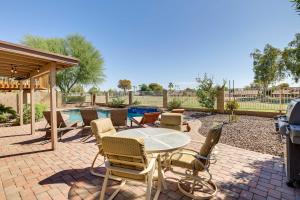 a patio with a table and chairs and a pool at Stunning Phoenix Oasis with Golf Course Views! in Phoenix