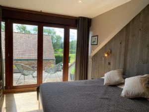 a bedroom with a bed and a sliding glass door at La Ferme Des Eglantines in Nivelles