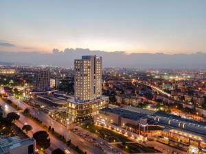 un perfil urbano por la noche con un edificio alto en DoubleTree by Hilton Manisa en Manisa