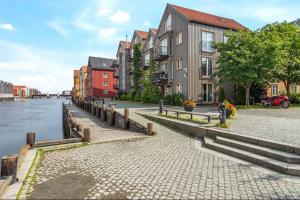 a row of buildings next to a river with houses at Bakklandets Perle 3-roms in Trondheim