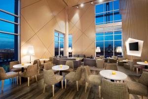 a restaurant with tables and chairs and windows at Hilton Garden Inn Al Khobar in Al Khobar