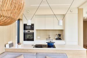 una cucina con armadi bianchi e piano di lavoro di NEW! Lofoten Luxury Home near Henningsvaer a Lyngværet