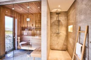 a bathroom with a shower and a glass wall at NEW! Lofoten Luxury Home near Henningsvaer in Lyngværet