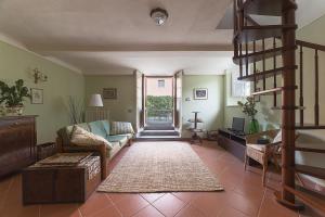 ein Wohnzimmer mit einem Sofa und einer Treppe in der Unterkunft Casa Orsolini in Lucca