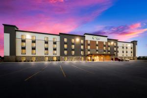 un gran edificio con un estacionamiento delante de él en WoodSpring Suites East Lansing - University Area en East Lansing