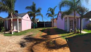 a row of pink houses with palm trees at Casitas del Sol in Caseros +7 photos