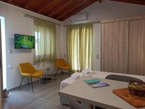 a room with a bed and chairs and a tv at Studio Marianna in Oziás