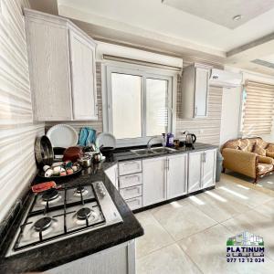 a kitchen with a stove and a counter top at Platinum 1 Villa in Al Salt