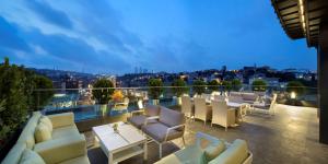 a balcony with white chairs and tables on a building at DoubleTree by Hilton Istanbul - Piyalepasa in Istanbul