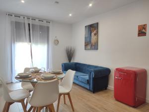- un salon avec une table et un canapé bleu dans l'établissement Apartamento Inés y Manolo, à Cordoue