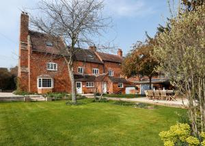 a large red brick house with a yard at The Old School House in Evesham