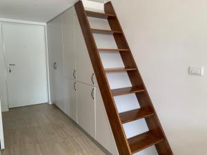 a ladder leading up to a room with white cabinets at Sunny studio apartment Chiara in Tivat