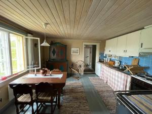 eine Küche mit einer Holzdecke und einem Tisch in der Unterkunft Little Guesthouse Cabin, Once Home to Lotta Svärd in Raasepori