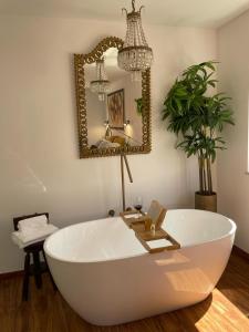 a large white bath tub in a room with a mirror at stressfree charm house in Odeceixe