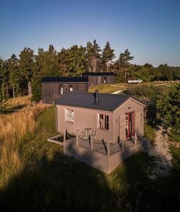 una pequeña casa en medio de un campo en Ragnar Glamp Milzkalne Forest, en Rauda