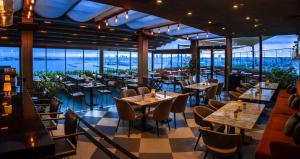 un restaurant avec des tables, des chaises et des fenêtres dans l'établissement DoubleTree By Hilton Istanbul - Moda, à Istanbul